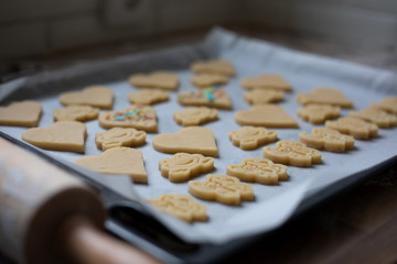 Homemade sugar sprinkled heart, frog and butterfly shaped butter cookies on a baking tray ready for baking