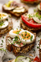 Buckwheat bread sandwich with boiled egg and chives on a wooden board. Close up view
