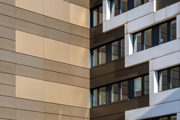 Golden building facade cladded with punched and perforated metal plates