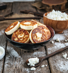 Side view on magnificent russian cottage cheese pancakes syrniki in a bowl, square format