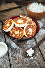 Side view on magnificent russian cottage cheese pancakes syrniki in a bowl, vertical
