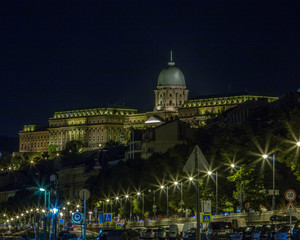 Fototapeta premium Buda Castle overlooking the Danube River and the lighted streets below in Budapest, Hungary