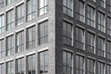 Fototapeta premium Modern facade of office building with dark bricks and big windows