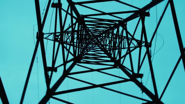 Transmission towers. Electricity pylons. Moving through electric high voltage pylon against beautiful sky in dusk. Energy efficiency conception