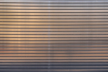 Stainless steel overhead door reflecting warm light of sun texture