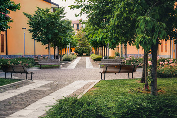 Italian street in summer. Green garden in Navigli district, Milan, Italy. Residential buildings in...