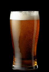 Glass of beer isolated on a black background.