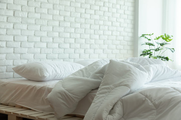 Messed bed with white pillow and blanket with natural light in bedroom in the morning,Messy bed after wake up,Messy bed and Cozy Bedroom Concept