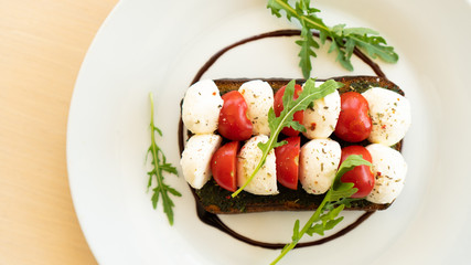 sandwich with mozzarella cheese and cherry tomatoes on a plate. Top view