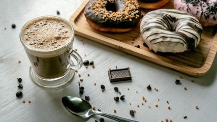 Coffee with donuts of different flavors. Appetizing donuts.