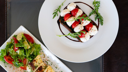 sandwich with mozzarella cheese and cherry tomatoes on a plate. Top view