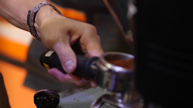 The barista is grinding the coffee into the stem and weighing it, taken with a specific focus technique.