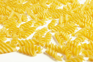 Raw fusilli pasta on a white background.