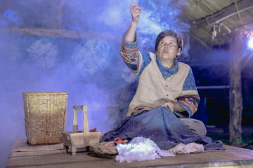 Craftsperson working. Old woman sewing homespun cotton cloth in community. Senior women use a...