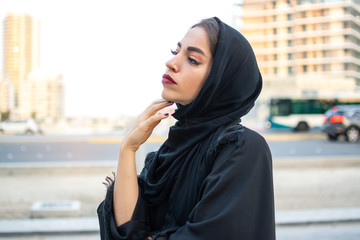 Portrait of beautiful middle eastern Arab woman in Abaya clothes outdoors