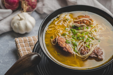Meatballs and Noodles Soup topped with Spring Onions (Close Up) - simply called Almondigas, is  a hearty Filipino dish consisting of meatballs and misua.