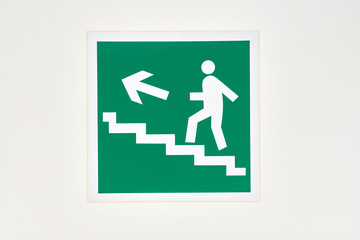 The sign of the direction to the evacuation exit on the wall in the shopping center