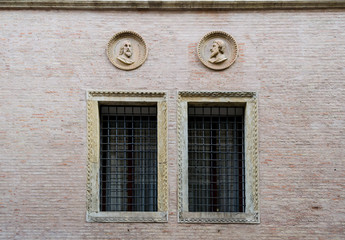 Fototapeta na wymiar Vicenza, Italy. A nice couple of window in a brick wall of one the the many beautiful palaces of this interesting town