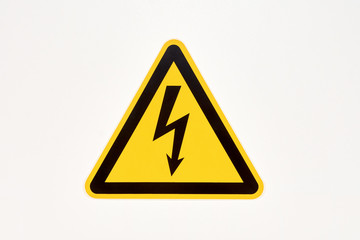 Danger sign of high voltage electricity. Yellow triangular mesh with a zipper in the center