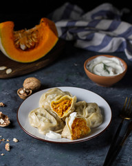 Manta rays with pumpkin filling and sour cream sauce on a plate.