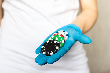 Poker chips showed on hand in blue protective gloves