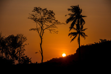 Sunset and the silhouette of hill trees