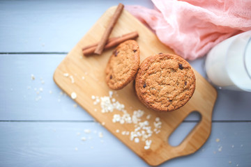 Oatmeal chocolate chip cookies with cinnamon and a glass of milk. Cookies on a wooden cutting board.