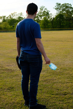 Images of young man wearing a COVID-19 mask at a closed baseball field.