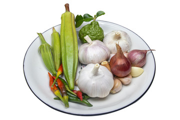 Thai spice Fragrant garlic, chilies, kaffir lime balls, okra in a white background dish