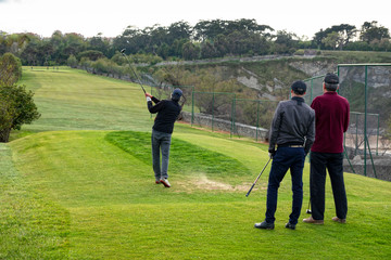 golfistas jugando al golf en un campo de golf ó grupo de amigos jugando al golf