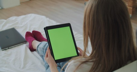 Woman lying on the bed with tablet computer
