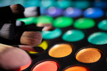 A set of makeup brushes is placed on the eyeshadow palette: extra macro 