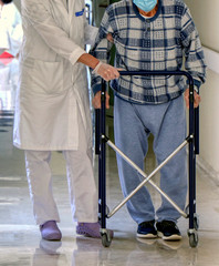 Physiotherapist working with an elderly patient doing mobility exercises