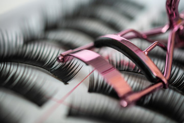 Set of false eyelashes in a box with Curling tweezers: close-up, extra macro, background, beauty salon concept