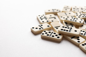 Ivory dominoes in a pile with a white background.