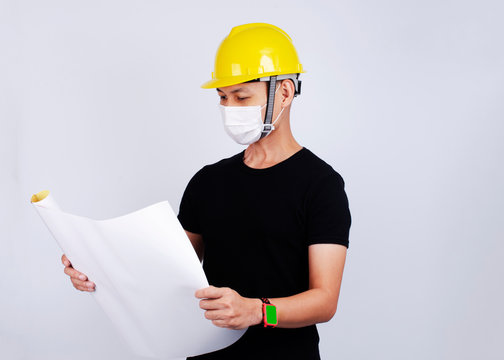 Men Engineer portrait wearing mask for protect pm2.5 and Covid-19 with hand holding drwing paper on white backgrounds