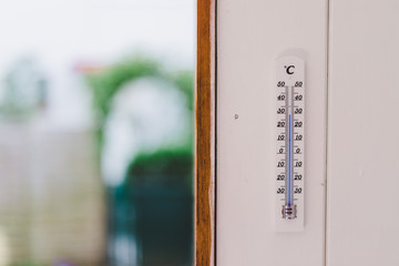 Naklejka premium Heatwave: Thermometer in summer on a blurry background, heat