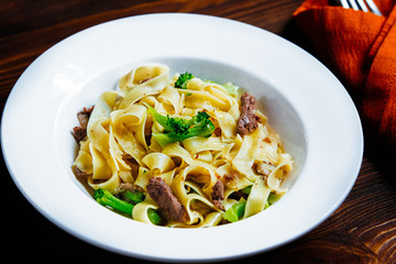 A pasta with meat and broccoli on a plate