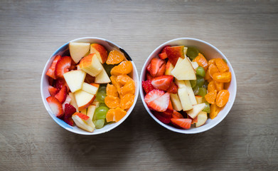 Fruit bowl: Strawberries, apple chunks, grapes and tangerines in a bowl