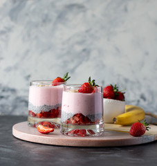 Chia seeds pudding with strawberry and banana in glasses, healthy tasty dessert