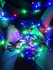 Colorful garlands in the hands of a guy for Christmas.