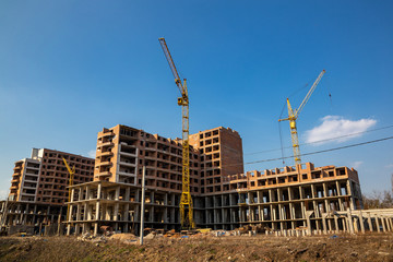 Work in progress on a new apartment block. Tall building under construction with cranes....