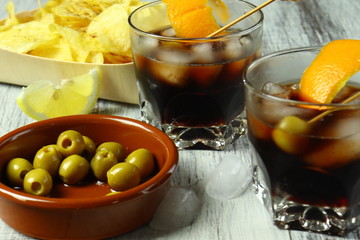 Aperitivo típico español con vermú, aceitunas, patatas fritas con limón y pimienta 
