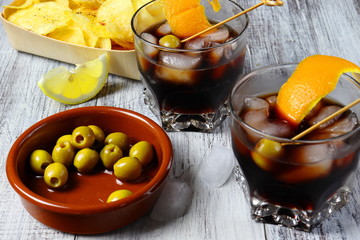 Aperitivo típico español con vermú, aceitunas, patatas fritas con limón y pimienta 