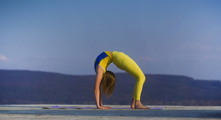 Young gymnast girl perform various gymnastic and yoga exercises, including splits and bending over...