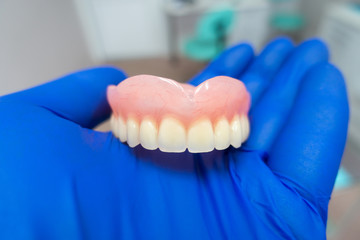 Fototapeta na wymiar removable denture in the hands of a doctor