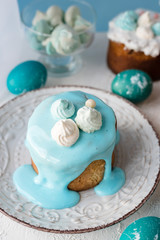 Beautiful easter cakes with meringues, kraffins on a blue background and blue colored eggs. Beautiful Easter decoration in blue tones
