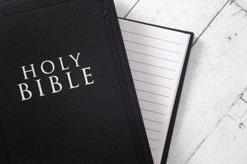 A Black Holy BIble on a White Wooden Table