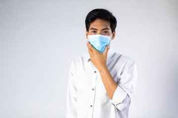 Studio portrait of Asian woman wearing face medical surgical mask, looking at camera, isolated on white background. Mask protection against virus. Covid-19, coronavirus pandemic