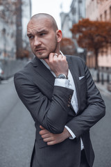 Portrait of young handsome business man in the city walking down the street